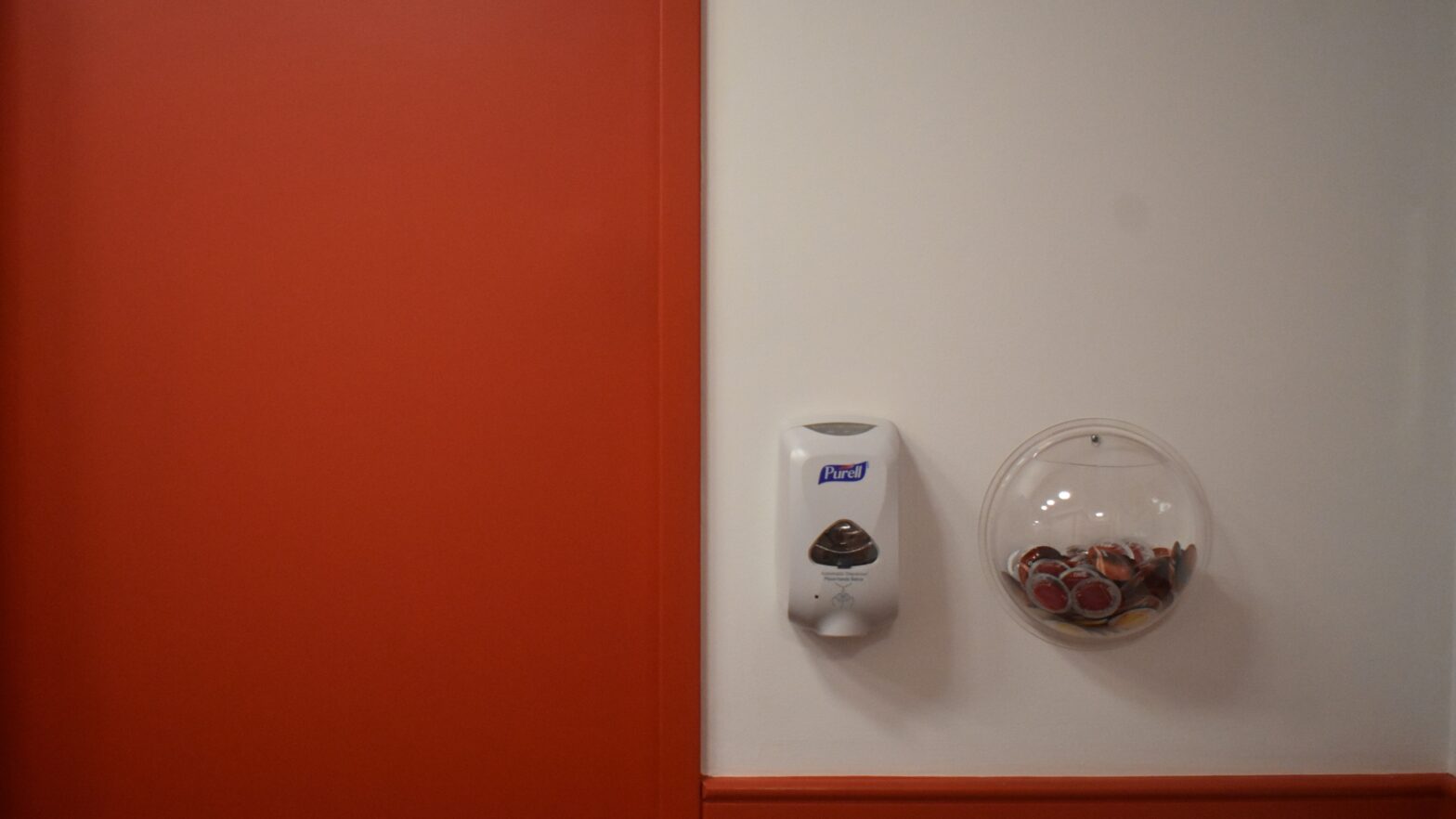 The New School’s Loeb Hall red elevator door and red condoms in a transparent bowl.