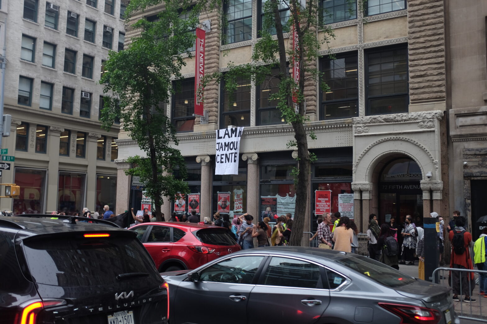 Image of the occupied Welcome Center. A banner hangs from a second floor window that reads 'Lama Jamou Center'