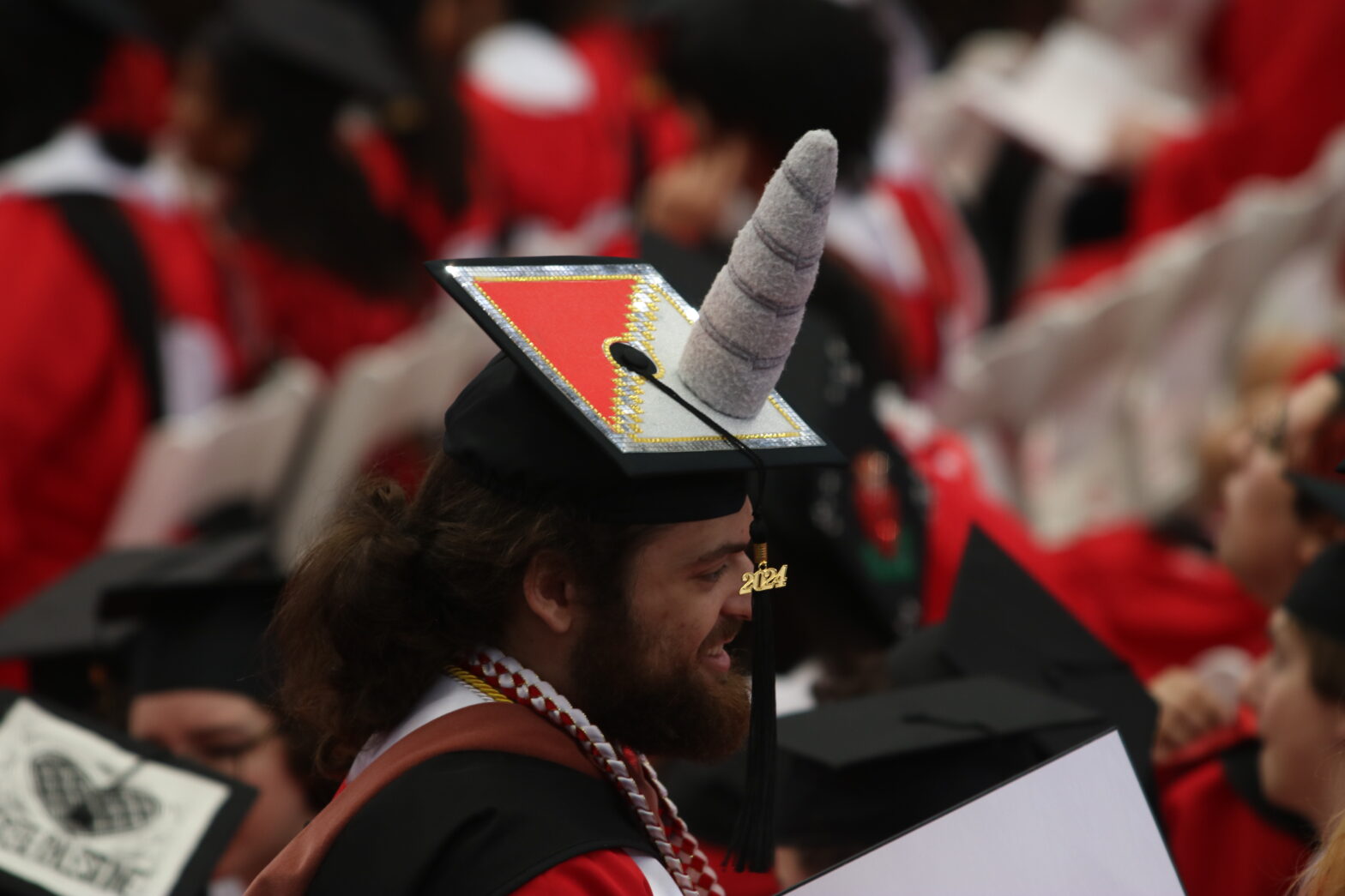 A student with a graduation cap on, with a narwhal horn attached to the top.