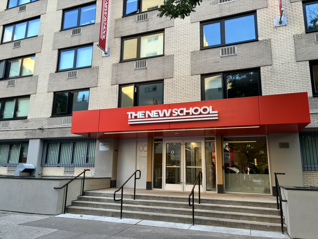 The front of Stuyvesant Park Residence, a large beige university building with a red awning that reads “The New School.”