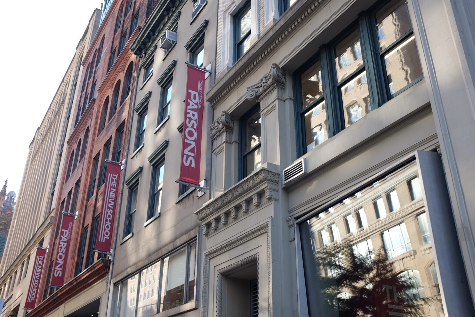 Banners outside a Parsons School of Design building reading “The New School” and “Parsons”