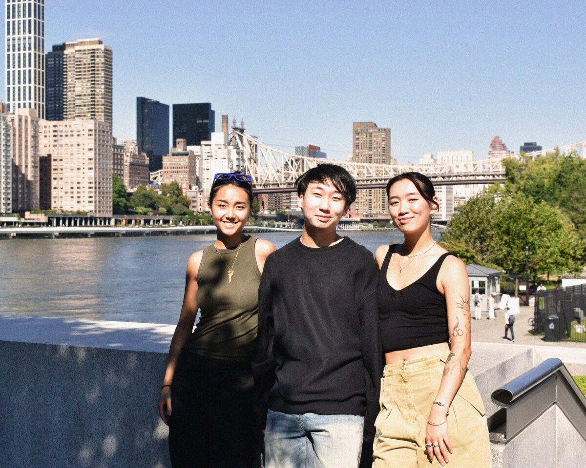 Three co-founders of FHD standing together in front of a river and cityscape backdrop, with the skyline and bridge visible in the background.