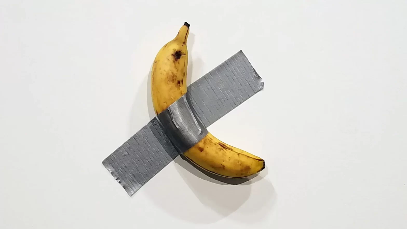 A banana duct taped on the wall.