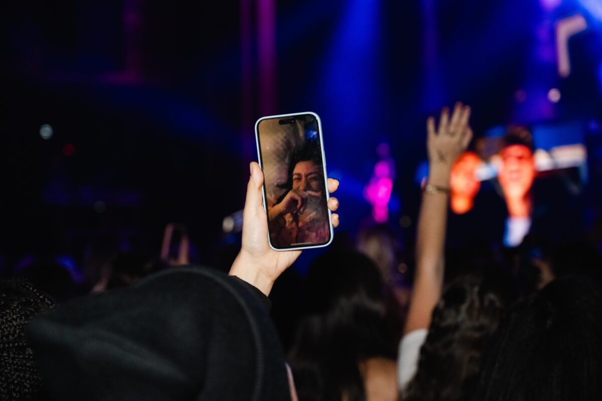 A hand holding a phone on a facetime call with a crying person