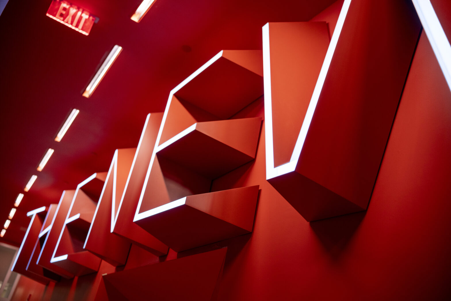 "The New School" sign in the university center in red with white lights outlining each letter