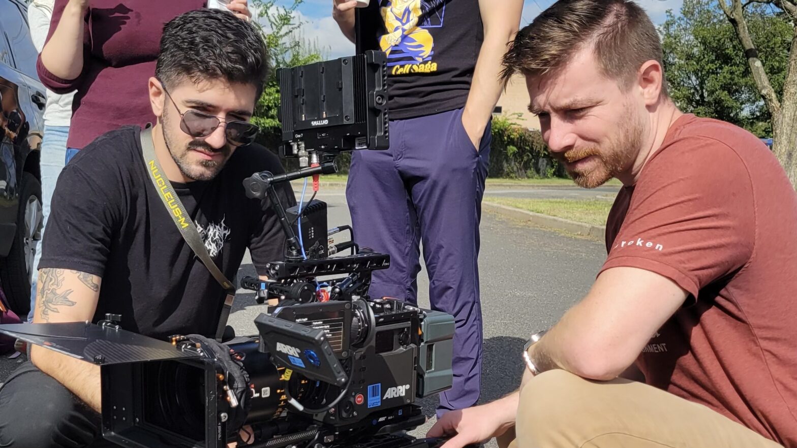 Two men gathered around a camera outside