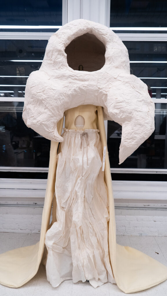 Structural dresses and headpieces on displayed mannequins.