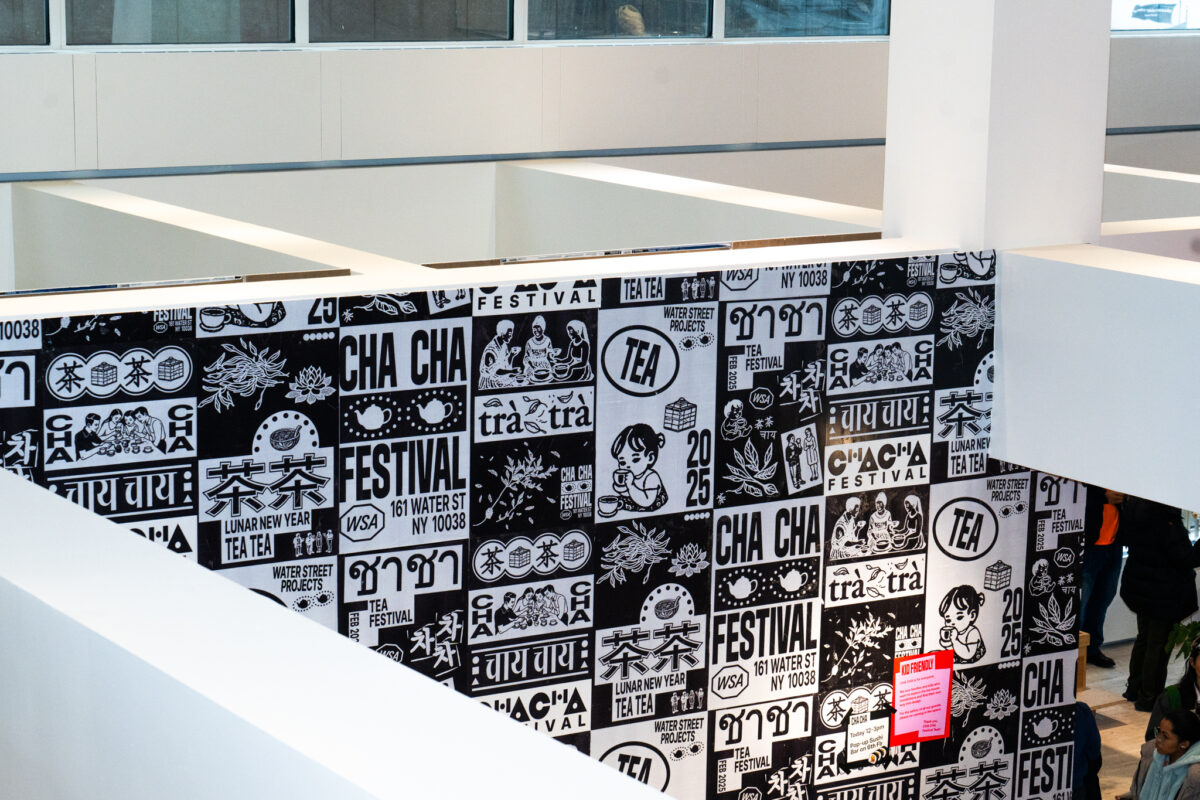 A high-angle view of the black-and-white wall at Cha Cha Festival, with bold typography and illustrations. 