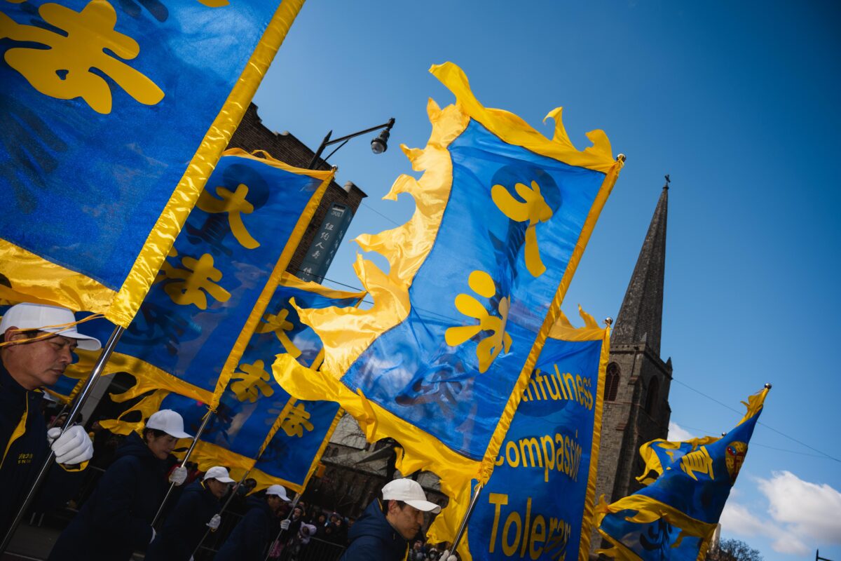 Blue and gold banners, reading ‘Da fa,’ held by members of the organization Falun Dafa. 