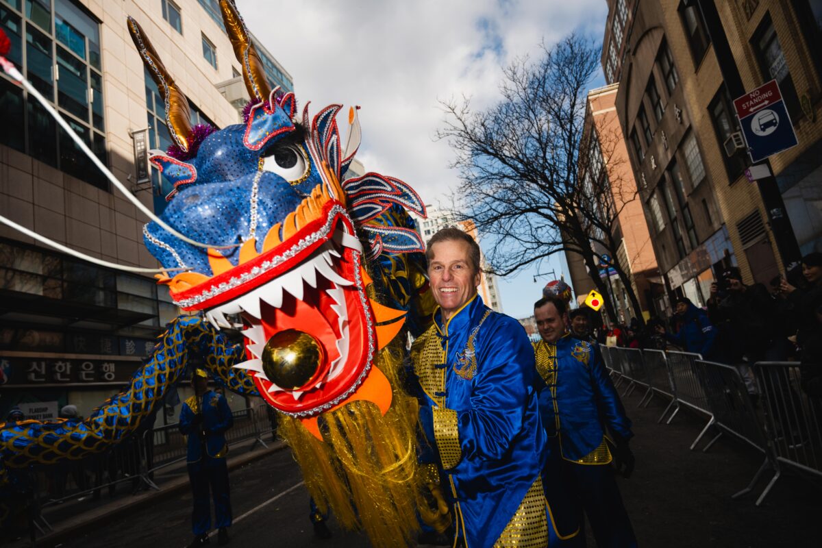 A performer, operating the head of a blue dragon puppet. 