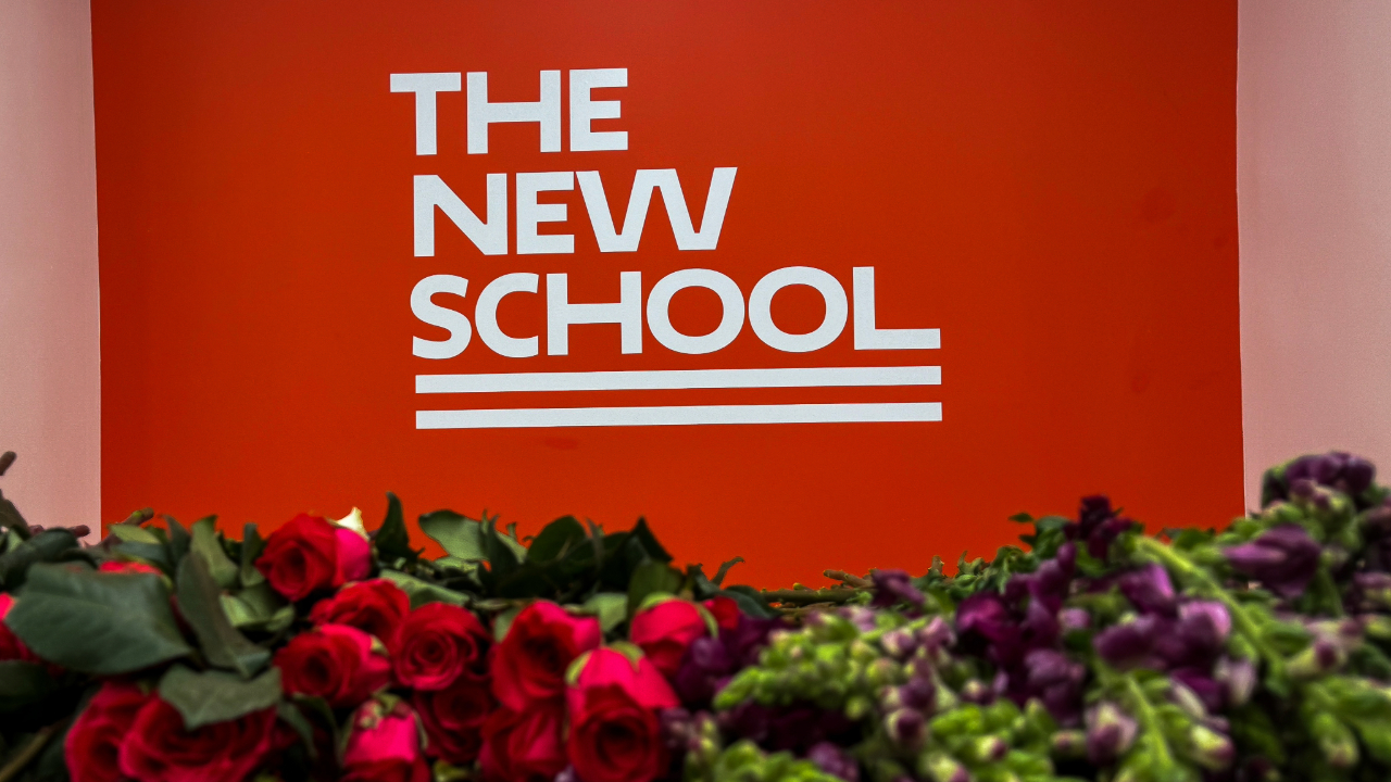 An image of The New School’s logo behind an array of flowers.