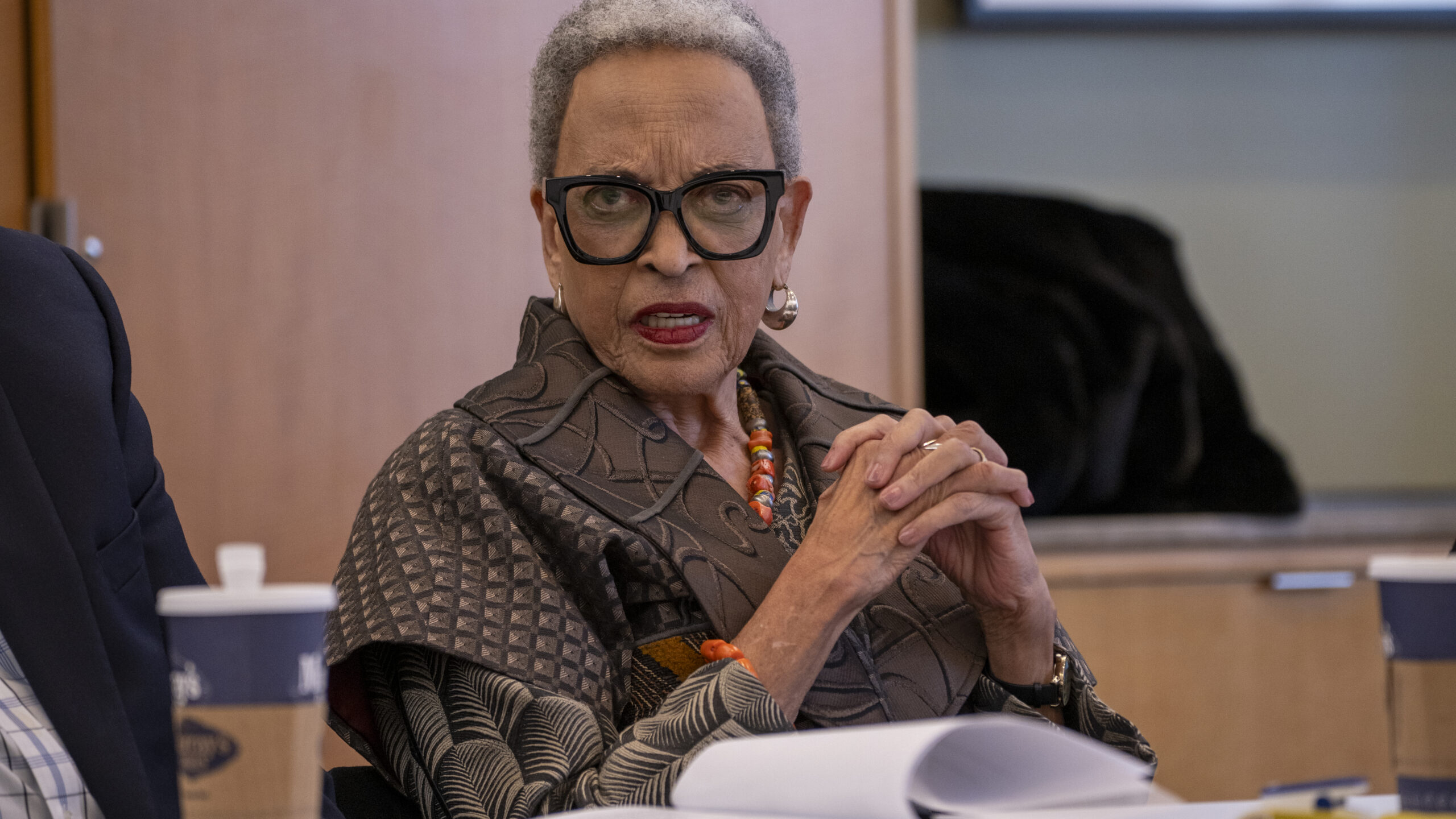 Portrait of Dr. Johnnetta B. Cole sitting at a table with her hands clasped.